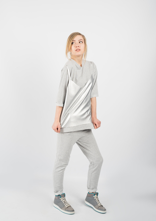 Young hipster girl wearing grey casual clothes and sneakers posing isolated on white backgroundの写真素材