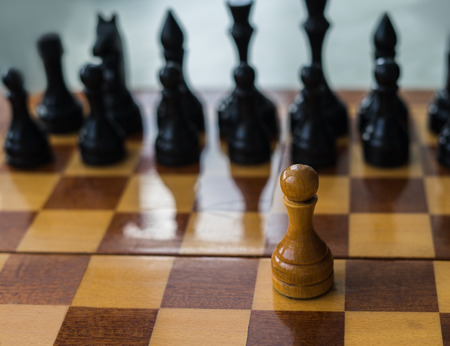 White chess pawn alone on a chessboard. conceptual photo of fighting alone and overcome the life difficulties alone. Self motivation.の写真素材