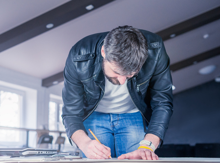 professional architect man drawing construction project on desk. business workflow. office conceptの写真素材
