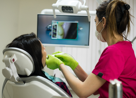 Dentist examining womans teeth with cameraの写真素材