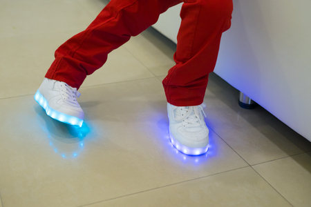 boy wearing glowing white led sneakersの写真素材