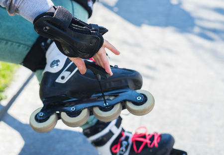 Roller girl unscrewing wheels on roller Skates with Allen keyの写真素材