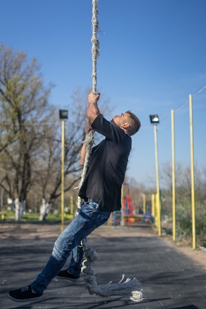 Young Athlete climbing up the Fitness rope