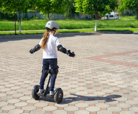 Small girl learns to ride electric mini hoverboardの写真素材
