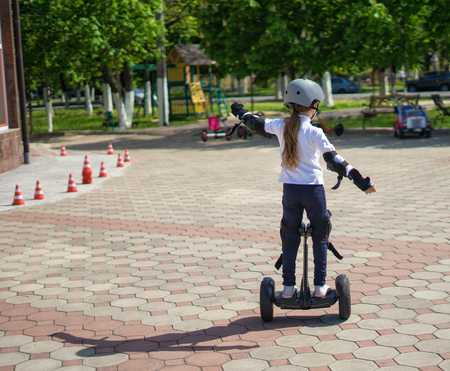 Small girl learns to ride electric mini hoverboardの写真素材
