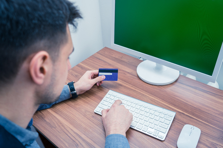Office worker holding credit card and making online purchaseの写真素材