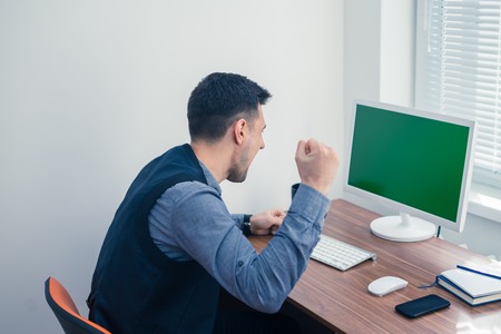 Furious young businessman ready to smash his computerの写真素材