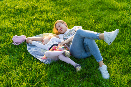 Happy Mother and daughter smiling at the park having picnicの写真素材