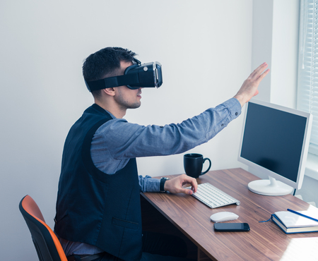 Young businessman in vr glasses drawing chart with gestureの写真素材
