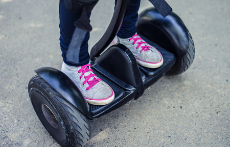 girls legs wearing sneakers riding gyroscooter or hoverboard