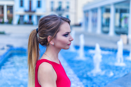 Beautiful young business woman sitting at the city squareの写真素材