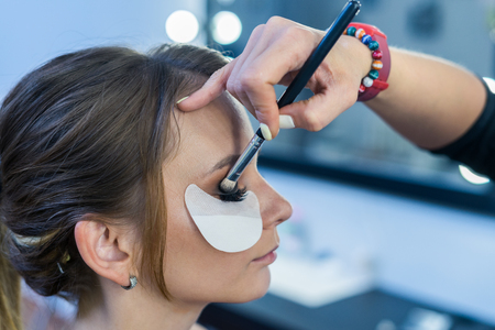 Make-up artist doing makeup to beautiful young girlの写真素材