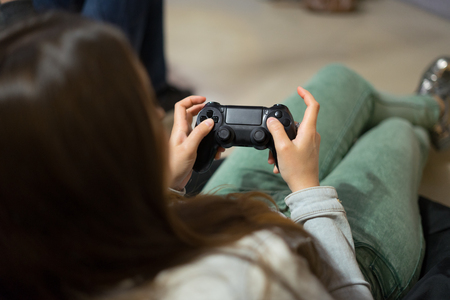 gamer girl playing video games with joystick sitting on Bean bag chairの写真素材