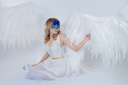 beautiful young model with big angel wings sitting in the studioの写真素材
