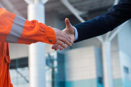 Moment before handshake of suit and boilersuitの写真素材