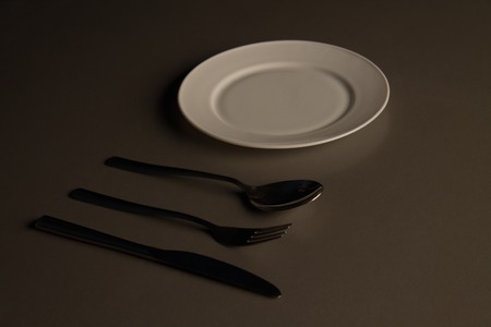 Empty plate with spoon, knife and fork. low keyの写真素材