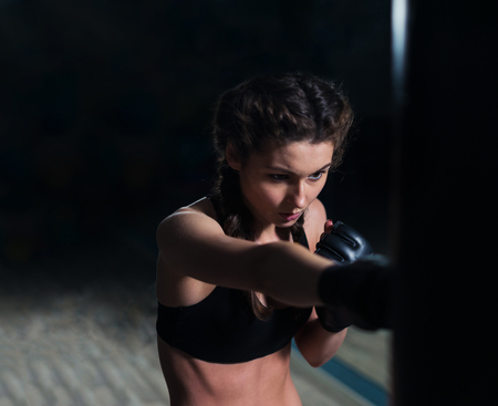 Beautiful young fighter boxer fit girl wearing boxing gloves inの写真素材