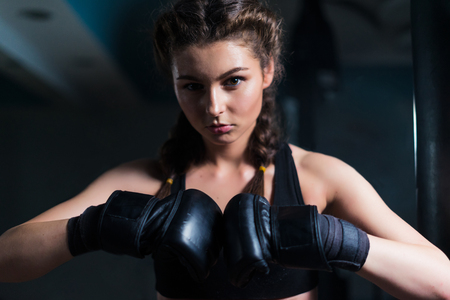 Young fighter boxer girl wearing boxing gloves before  training.の写真素材
