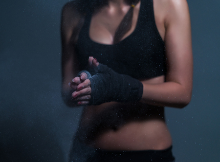 Young fighter boxer fit girl wearing hand bandage preparing agneの写真素材