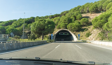 modern road tunnel with mountains and green treesの写真素材