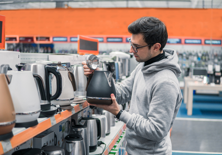 customer chooses a kettle in supermarket mallの写真素材