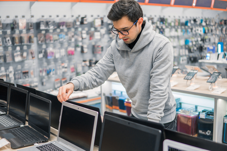 modern male customer choosing laptop in the computer shop