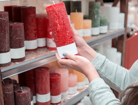 woman hands choosing festive decorative candles for Christmas or New Yearの写真素材