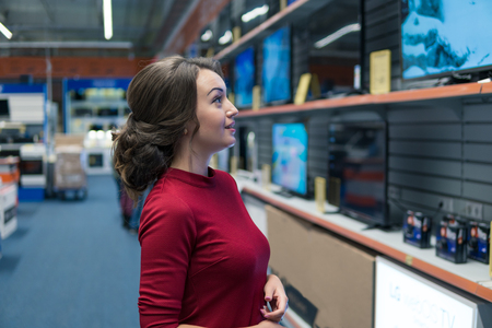 Smart modern female customer choosing large TV-setsの写真素材