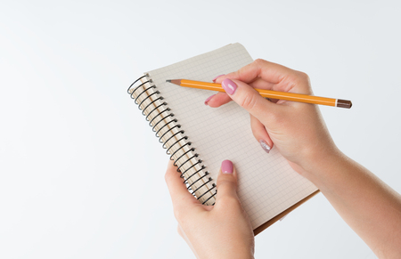 closeup view of hands with sketchbook and pencil on white backgroundの写真素材