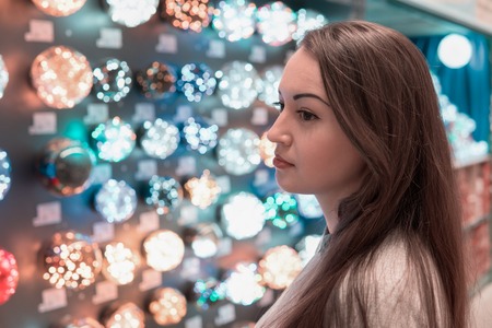 customer girl choosing Christmas tree decorations - garlandsの写真素材