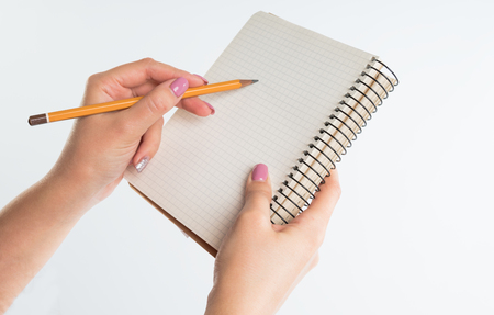 closeup view of hands with sketchbook and pencil on white backgroundの写真素材