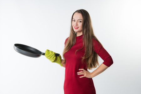 Young housewife holding pan and potholder isolated on white backgroundの写真素材