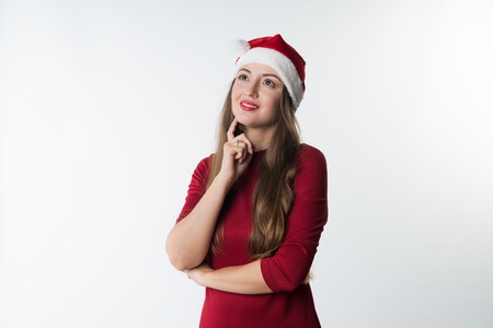 woman wearing red santa claus hat dreaming having ideaの写真素材