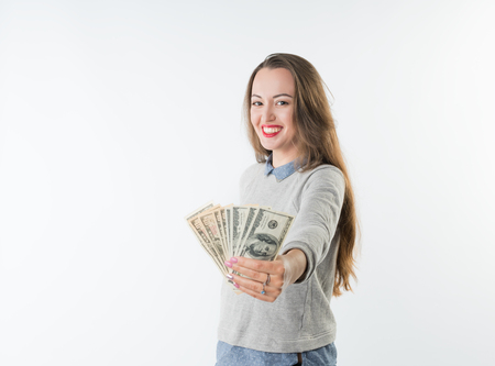 oung woman holding dollars cash and happy smiling isolatedの写真素材
