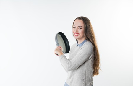 Angry smiling woman with insult laugh on her face and frying panの写真素材