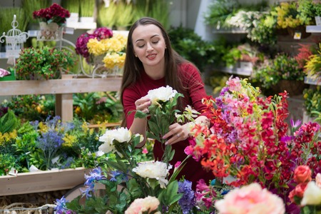 Beautiful woman buying flowers at flower shop. Happy women momentsの写真素材