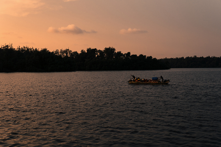 Silhouette of african unrecognizable fishermen canoe boat at seaの写真素材