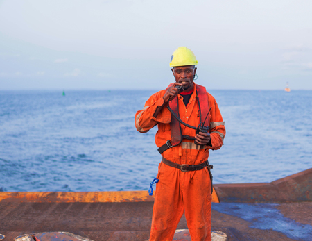 Seaman AB or Bosun on deck of offshore vessel or ship , wearing PPEの写真素材