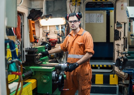 Marine engineer working in ships workshop in engine control roomの写真素材
