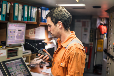 Marine Engineer working on radio communication at Engine Control roomの写真素材
