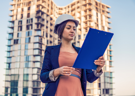 beatiful business woman engineer is standing with plan papers.の写真素材