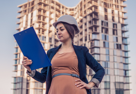 beatiful business woman engineer is standing with plan papers.の写真素材