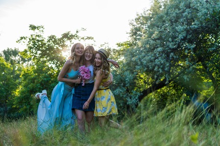 Group of girls friends with flowers having fun outdoorsの写真素材