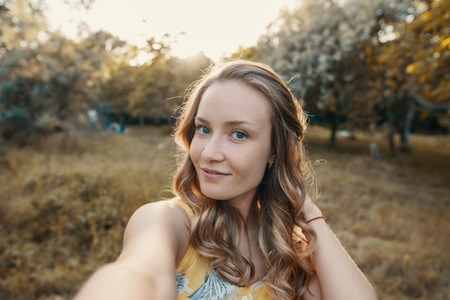 Stylish modern girl taking a selfie out in the park
