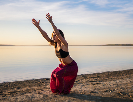 Silhouette yoga woman on the beach at sunset.の写真素材