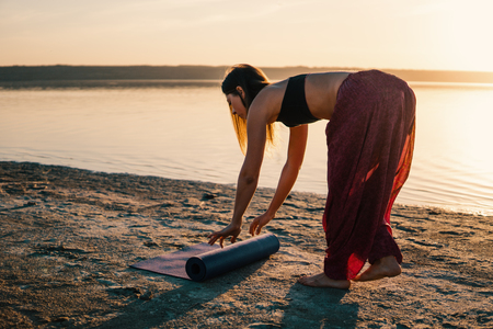 yoga woman on the beach at sunset.の写真素材
