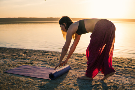 yoga woman on the beach at sunset.の写真素材