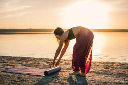 yoga woman on the beach at sunset.の写真素材
