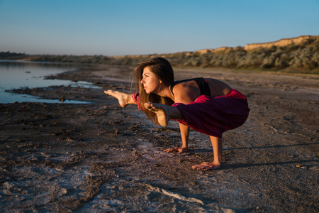 yoga woman on the beach at sunset.の写真素材