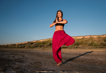 yoga woman on the beach at sunset.の写真素材